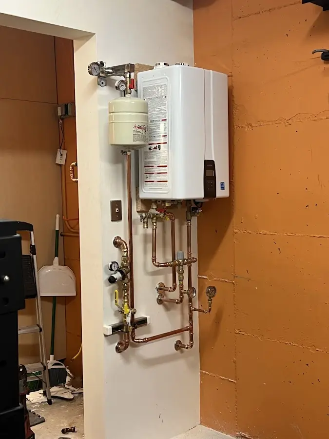 Plumbing technician inspecting water heater connections in Vinings